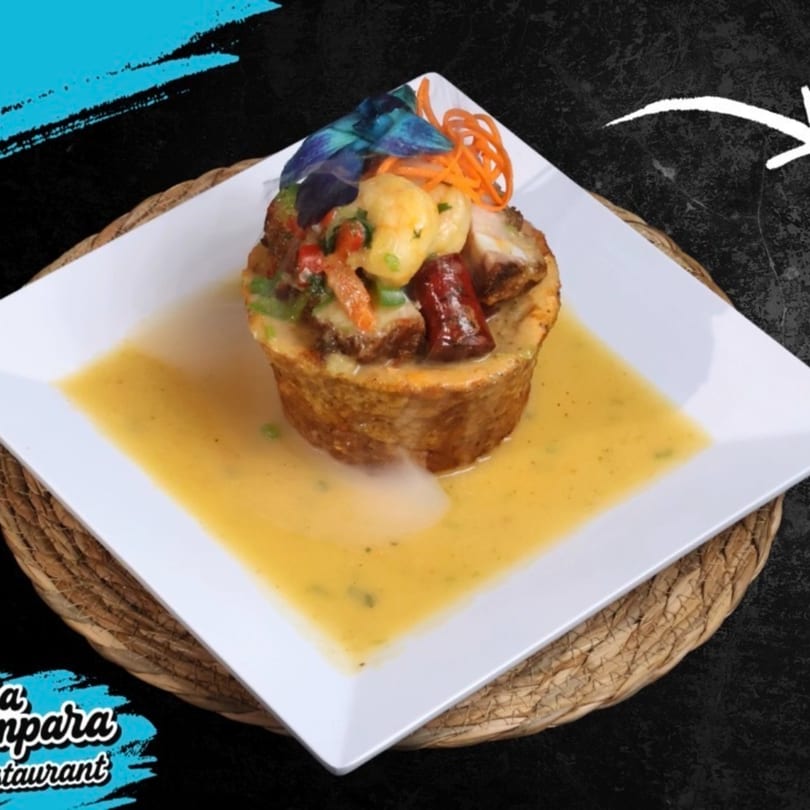 A savory dish with meat, vegetables, and a creamy sauce, served on a white plate.
