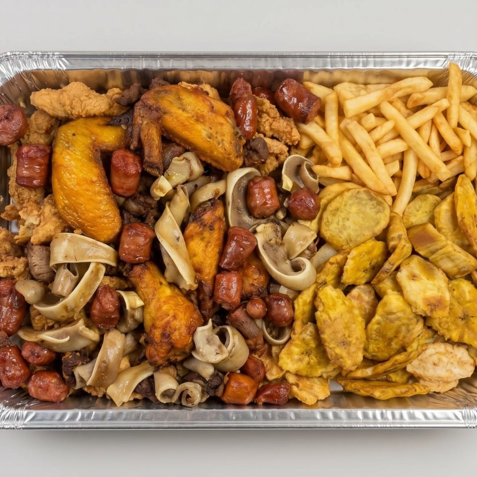 A large foil tray filled with fried chicken, sausages, fries, plantains, and mushrooms.
